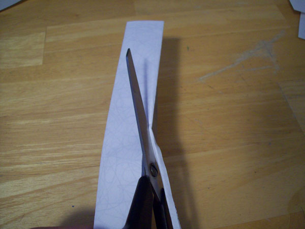 Cutting the edges off of the folded sheet.